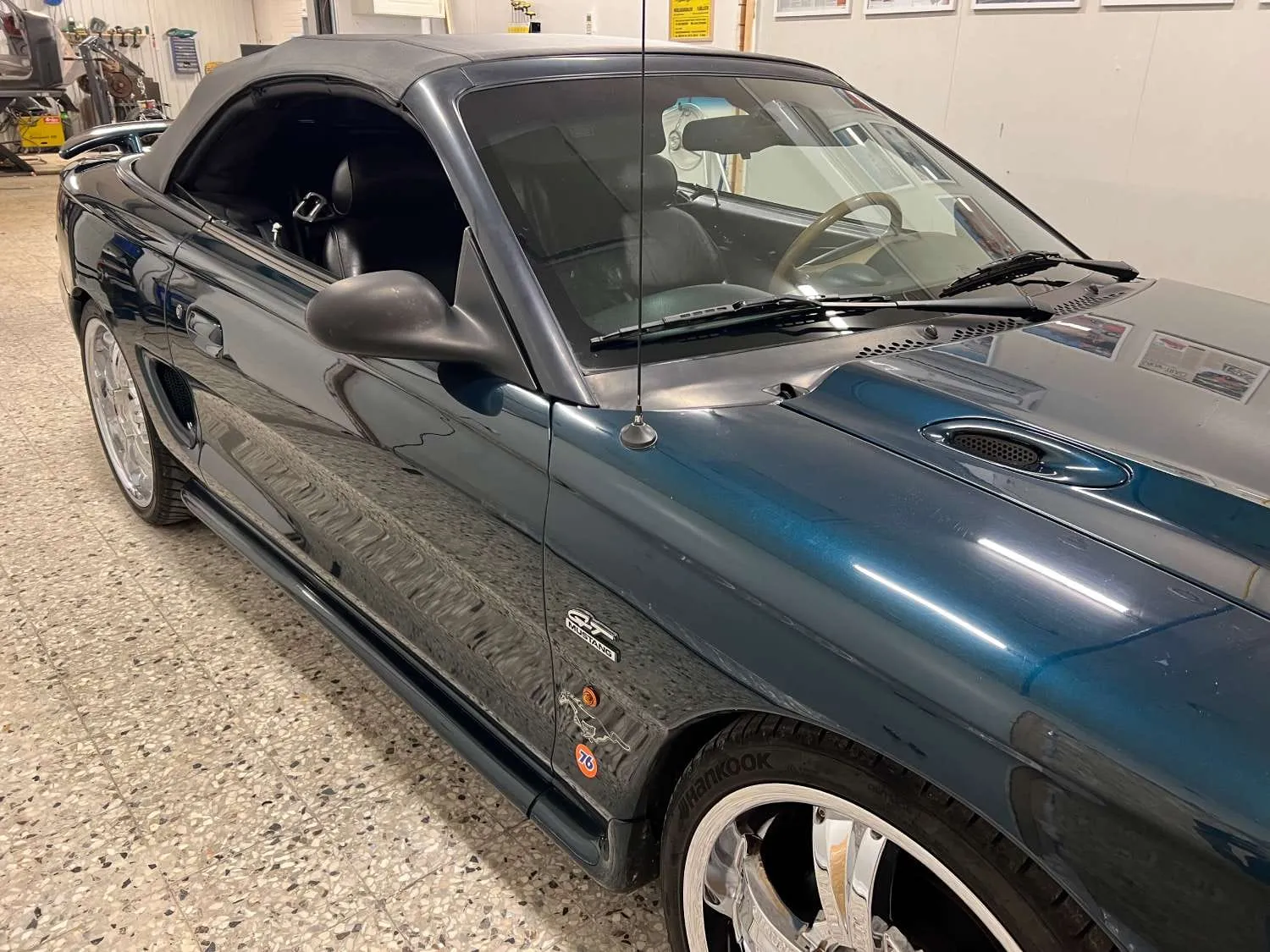 Mörkgrön Ford Mustang cabriolet i verkstaden