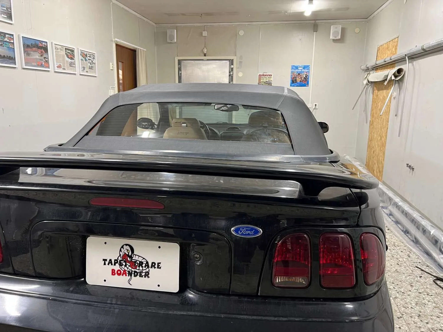 Svart Ford Mustang cabriolet bakifrån med Tapetserare Boanders skylt