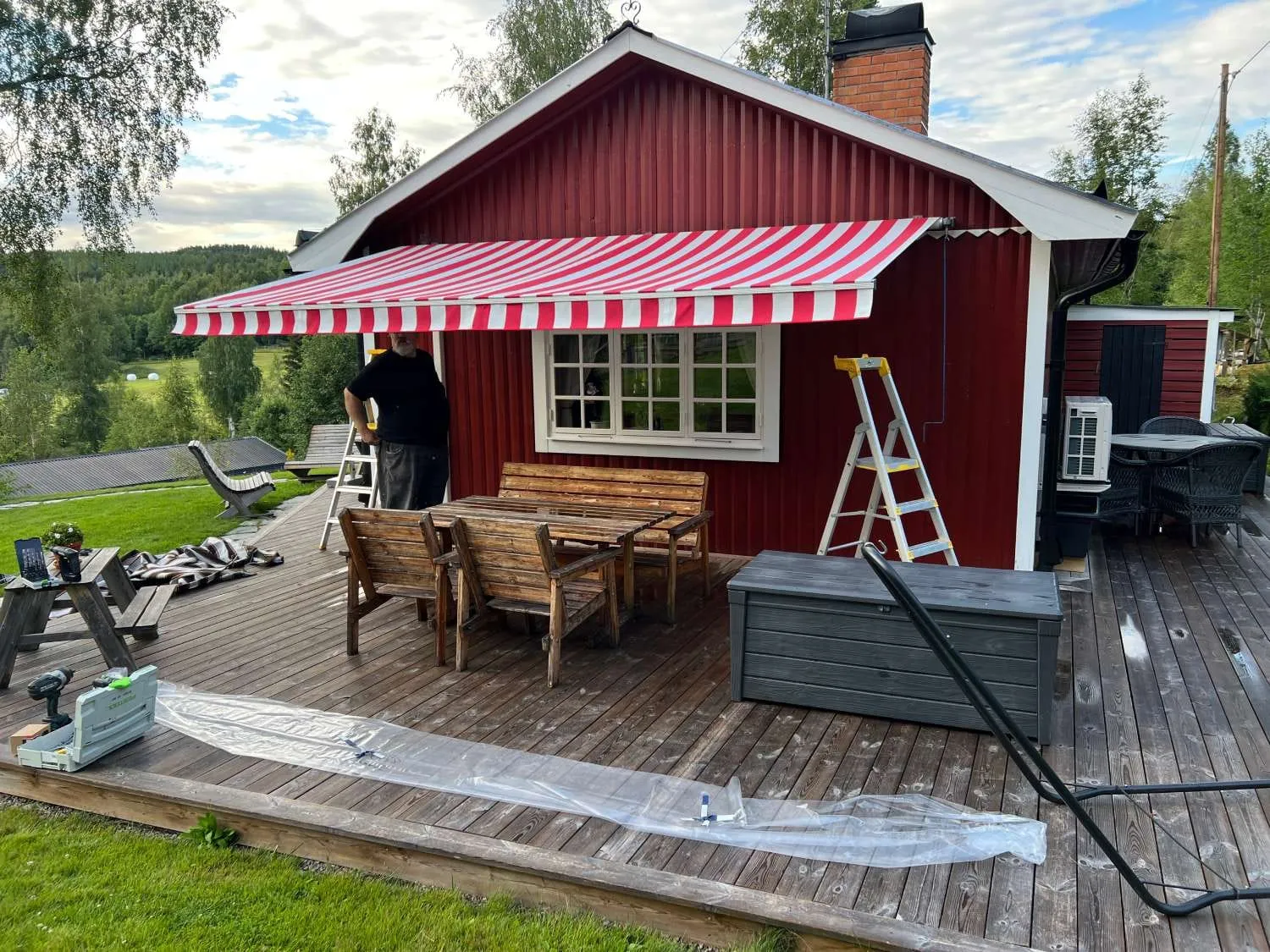Rödvit randig markis på en röd stuga
