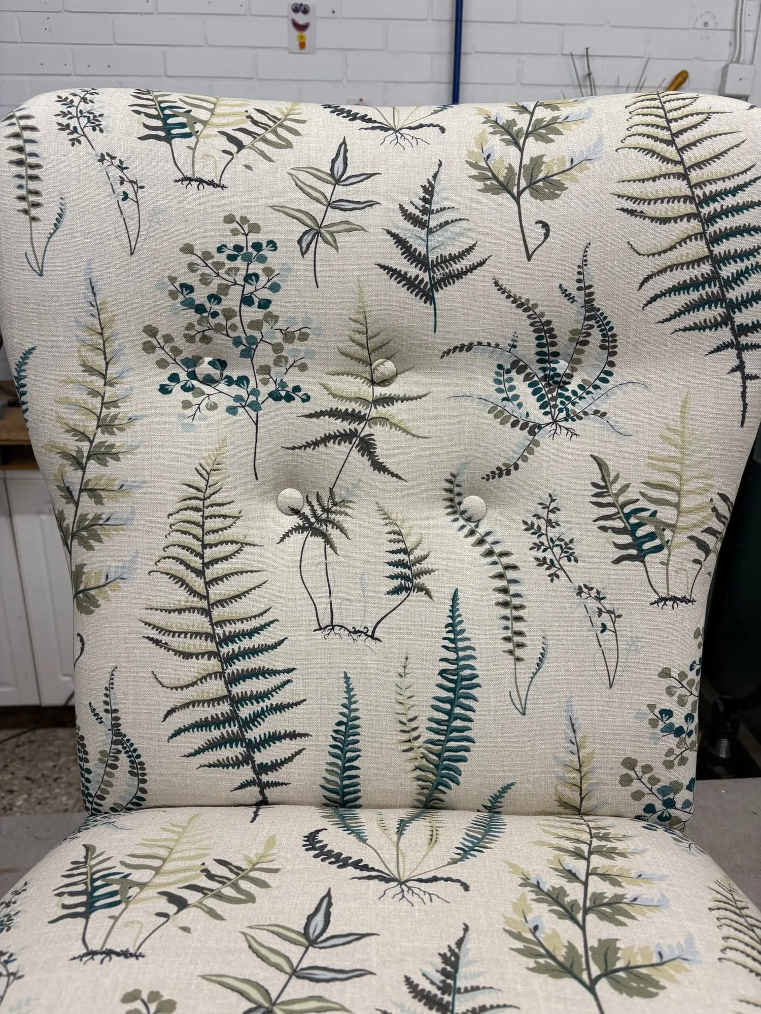 Detalj av ryggen på en fåtölj med ormbunksmönster